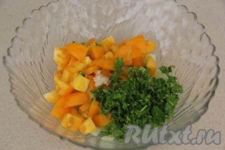 Соединить в салатнике огурцы, мелко нарезанную зелень, помидоры и пропущенный через пресс зубчик чеснока.