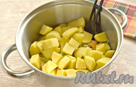 Обжаренные капусту, морковку и лук перекладываем со сковороды в достаточно объёмную кастрюлю (или в сотейник, или в казан), добавляем нарезанный картофель.
