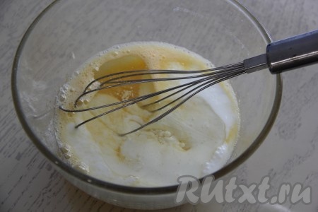 В получившуюся яично-сахарную смесь влить кефир и растительное масло, тщательно перемешать тесто венчиком.