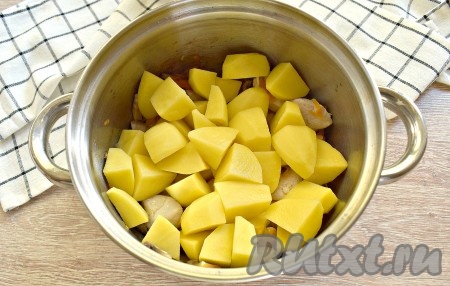 Крупно нарезаем очищенные картофелины, выкладываем их к курице и шампиньонам.