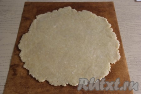 Раскатать тесто на пергаменте (или на тефлоновом коврике) с помощью скалки в круг диаметром, примерно, 30 см.