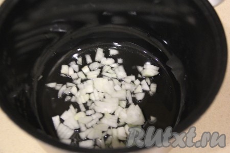 Лук и морковь очистить. Влить в чашу мультиварки растительное масло и выложить мелко нарезанный лук.