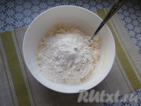 Сюда же всыпать ванильный сахар и сахар, перемешать, добавить муку с разрыхлителем, начать перемешивать вначале ложкой творожное тесто.