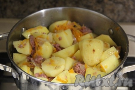 Перемешать картошку с тушёнкой, накрыть кастрюлю крышкой, дать воде закипеть и тушить блюдо минут 25 на умеренном огне.