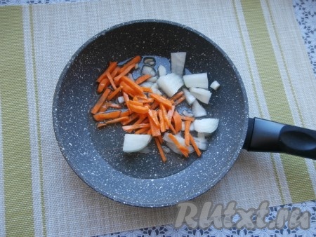 Луковицу нарезать на небольшие кусочки, морковку - соломкой (или брусочками), переложить на сковороду, уже разогретую с 2-3 столовыми ложками растительного масла.