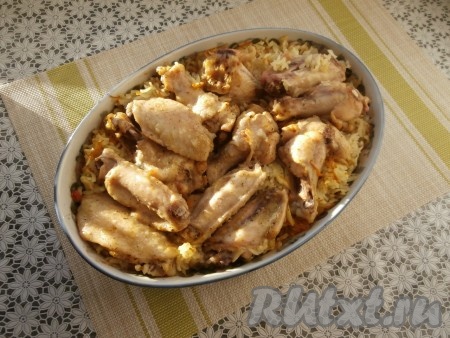 Готовить рис с куриными крыльями минут 50 под фольгой, затем фольгу убрать и поместить блюдо в духовку ещё минут на 15.