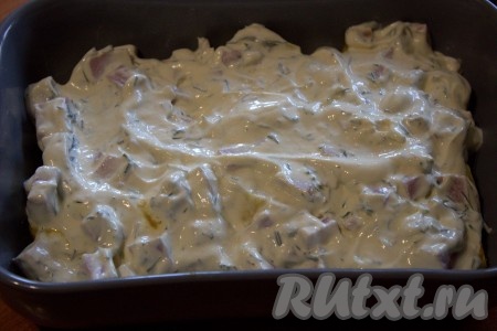 Поверх картошки выложить ровным слоем смесь ветчины и сметаны. Отправить картофель с ветчиной запекаться минут на 20 в разогретую до 180 градусов духовку.