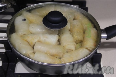 Накрыть сковороду крышкой и тушить голубцы с картошкой на среднем огне с момента закипания 40-45 минут.