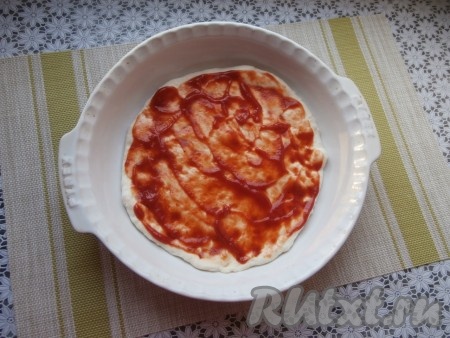 Форму для пиццы (я выпекала в форма диаметром 26 см) смазать растительным маслом, выложить тесто, растянуть его по всей форме. Тесто смазать томатным соусом (или кетчупом).