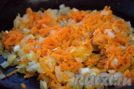 Тем временем очистить луковицу и мелко нарезать. Натереть очищенную морковку на средней тёрке. В сковороде прогреть небольшое количество растительного масла, выложить лук и обжарить его на среднем огне до прозрачности (минуты 3), не забывая периодически перемешивать, затем добавить морковь и, помешивая, обжаривать овощи ещё минут 5.