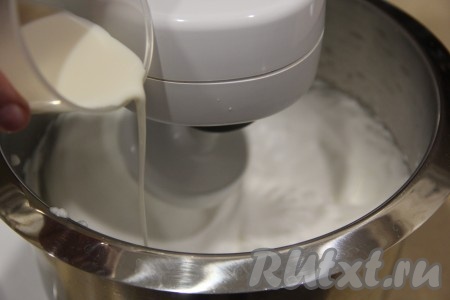 Затем, продолжая взбивать, в белки влить тонкой струйкой 50 мл холодного молока.