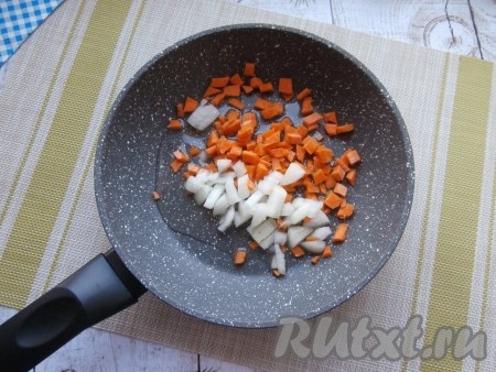Пока картошка варится с куриными крылышками, приготовим овощную зажарку для супа, для этого лук и морковку нужно нарезать на мелкие кубики, поместить в сковороду, влить растительное масло.