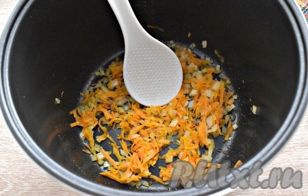 В чашу мультиварки наливаем масло. Включаем на дисплее режим «Жарка». В чашу перекладываем измельчённые морковь и лук. Периодически перемешивая лопаточкой, обжариваем овощи 5-7 минут (до мягкости).