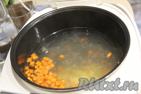 Бульон процедить и вернуть в чашу мультиварки. Выставить режим "Суп" на 30 минут. Картошку и морковь нарезать на кубики, выложить в чашу мультиварки. 