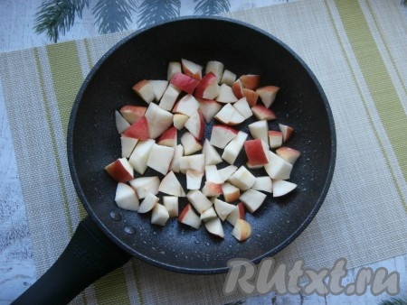 Толстостенную сковороду смазать 1 чайной ложкой растительного масла, выложить в один слой предварительно очищенные от семян и нарезанные кубиками яблоки.
