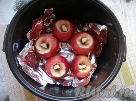 Чашу мультиварки застелить фольгой, разместить в ней яблоки. В углубление каждого яблочка всыпать немного корицы, выложить по маленькому кусочку сливочного масла.