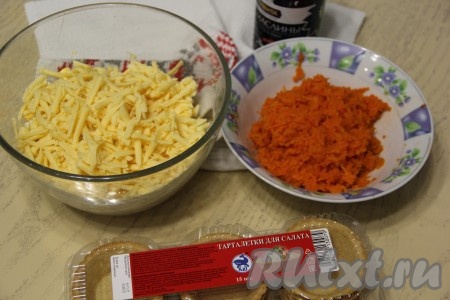 Всыпать сыр в салатник. В отдельную тарелку на мелкой тёрке натереть очищенную варёную морковку.