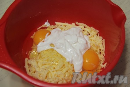 В эту же миску добавить сырые яйца и сметану, перемешать венчиком сырную массу.