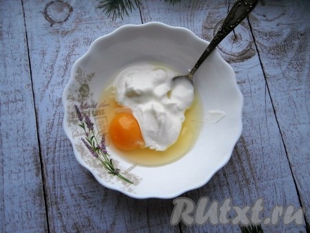 Теперь приготовим заливку, для этого в отдельную тарелку нужно выложить сметану, добавить сырое яйцо и немного соли, хорошенько перемешать венчиком.