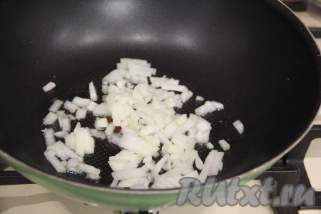 В сковороду с высокими бортиками влить немного растительного масла, выложить очищенный и достаточно мелко нарезанный лук. 