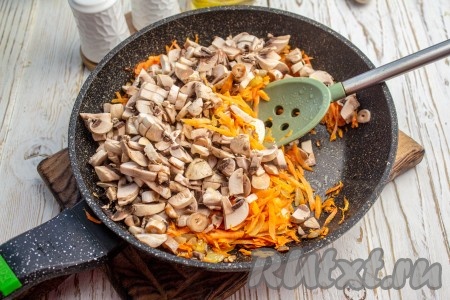 Шампиньоны нарежьте на небольшие кусочки, выложите в сковороду к овощам и обжаривайте минуты 3-4, время от времени перемешивая грибочки с морковкой и луком.