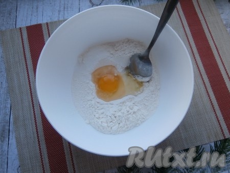 Замесим тесто для вареников, для этого муку нужно просеять в миску, добавить сырое яйцо и соль.