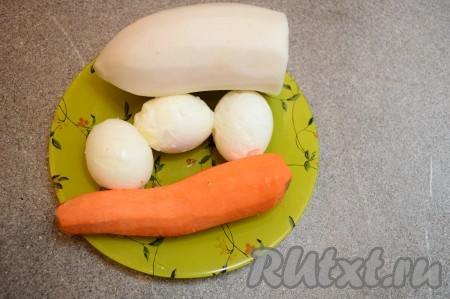 Подготовить продукты для приготовления салата из дайкона с яйцами и морковью.  Заранее отварить 3 яйца вкрутую (то есть отвариваем яйца после начала кипения воды минут 8-10), затем остудить их полностью и очистить от скорлупы. Дайкон и морковь очистить.