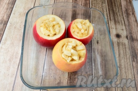 Выложить подготовленные яблоки в форму для запекания. Внутрь каждого яблочка вложить кусочки банана. 