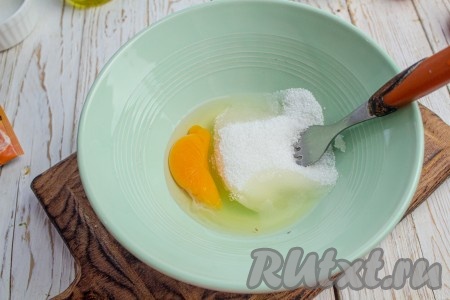 В глубокую миску вбейте яйцо, добавьте ванильный сахар и 70 грамм обычного сахара (30 грамм отложите). Смешайте вилкой до соединения ингредиентов.