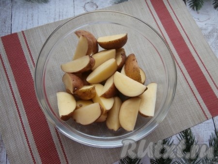 Разрезать каждую картофелину на дольки (на 4-6 частей). Выложить нарезанные картофелины в глубокую миску.