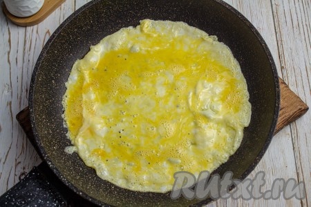 На сковороду диаметром 22-24 сантиметра, смазанную растительным маслом, вылейте яичную смесь, накройте сковороду крышкой и готовьте блин при среднем нагреве плиты 1,5-2 минуты. 
