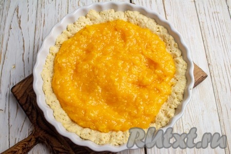 Достаньте слегка подпечённую песочную основу пирога из духовки и выложите на неё мандариновое пюре.