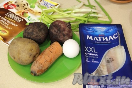 Подготовить продукты для приготовления роллов "Селёдка под шубой". Картофель и морковь отварить в кожуре в течение 25-30 минут с момента закипания воды. Отдельно отварить в кожуре свеклу в течение 50-60 минут с начала кипения воды. Отварить вкрутую яйцо (варить после закипания воды минут 9-10). Варёные овощи и яйцо полностью остудить, а затем очистить. Для формирования рулета потребуется, примерно, 100 грамм филе сельди целиком, нам понадобятся в дальнейшем длинные брусочки. Можно взять покупное филе спинок или разделать солёную селёдочку на филе в домашних условиях, тщательно удаляя косточки. Нарезать филе селёдки на длинные брусочки. Зелёный лук вымыть и обсушить.