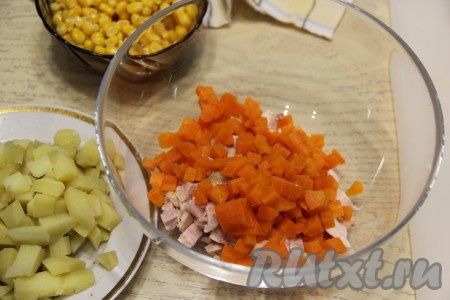 Варёные морковку с картошкой нарезать на кубики, примерно, одинакового размера. Вначале морковку выложить в салатник. 