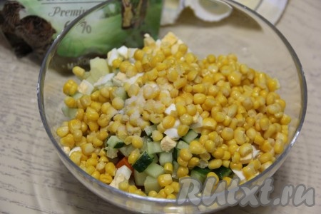 Выложить в салат консервированную кукурузу, посолить блюдо по вкусу.