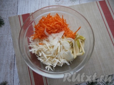 В достаточно объёмной миске соединить капусту, морковку, яблоко и лук.
