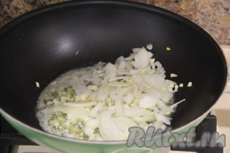 В сковороду с растопленным сливочным маслом выложить нарезанные чеснок и лук, обжарить, помешивая, в течение 2 минут на среднем огне.