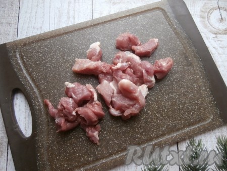 Нарезать на небольшие кусочки вымытую свинину.