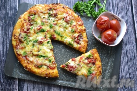 Пиццу с колбасой и солёными помидорами нарезать на кусочки и подавать в горячем виде.