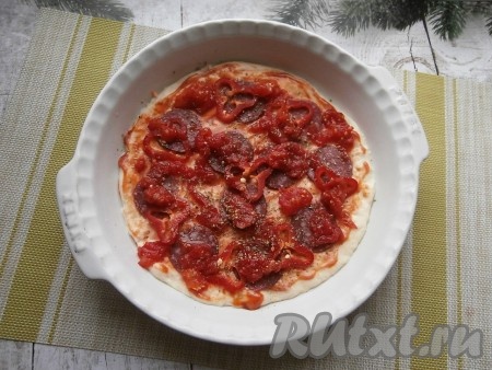 Нарезать помидоры или размять немного (у кого как получится) и выложить на колбасу и на перец. Посыпать пиццу чёрным молотым перцем и сухими травами.