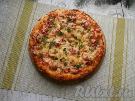 Красивая, очень румяная пицца готова! Вынуть её из формы и посыпать свежей зеленью.