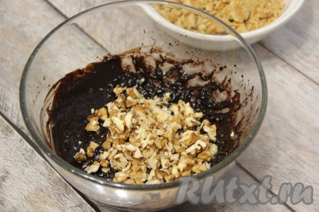 В получившуюся однородную шоколадную массу всыпать подготовленные орехи, перемешать столовой ложкой.