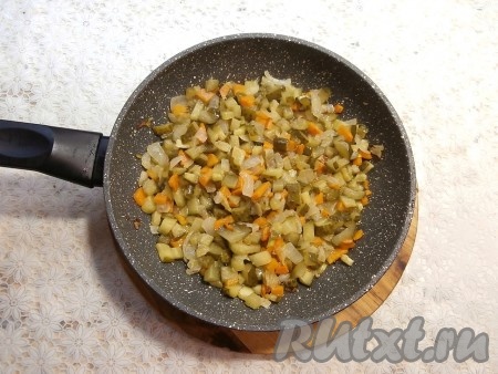 В сковороду с обжаренными овощами добавить солёные огурцы, перемешать.
