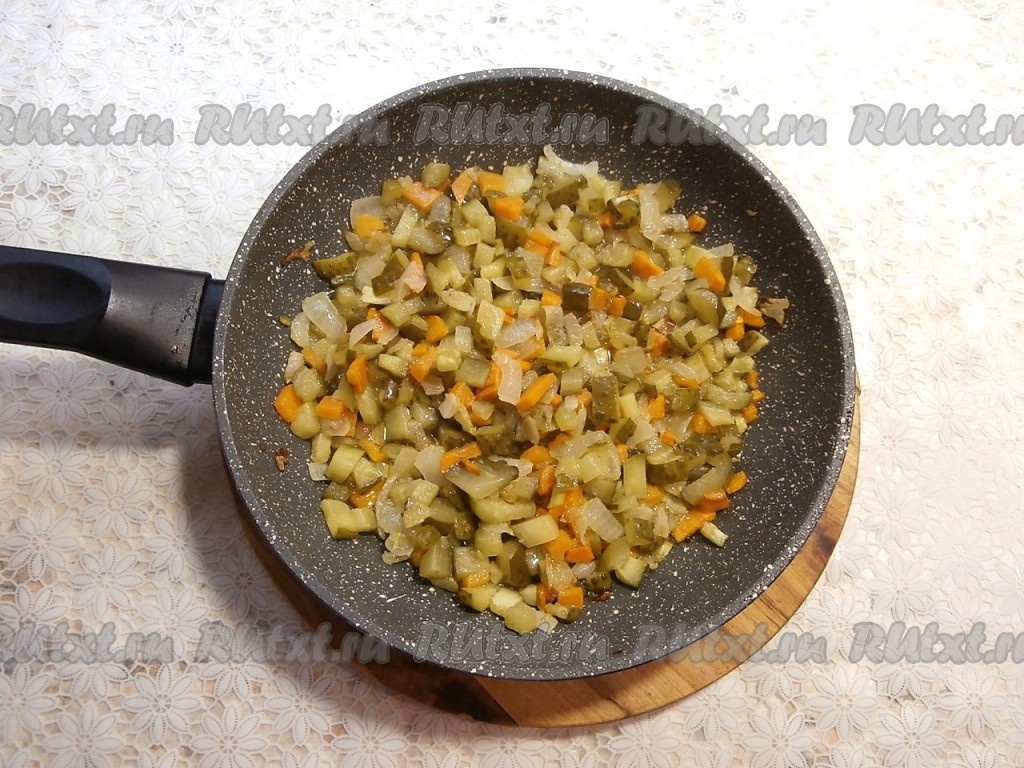 В сковороду с обжаренными овощами добавить солёные огурцы, перемешать.