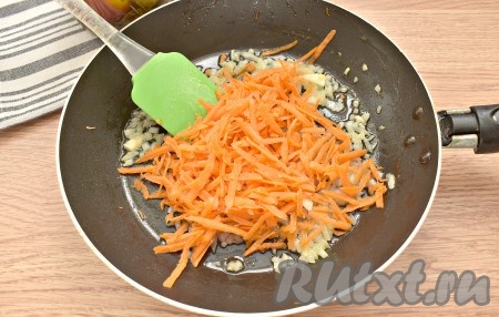 Очищаем и натираем на тёрке небольшую морковку, выкладываем её к луку и обжариваем, помешивая, 4-5 минут (до мягкости морковки).