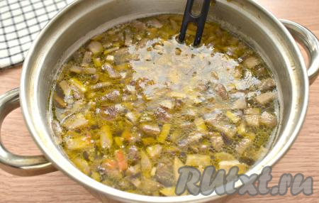 После того как гречка проварится 15 минут, перекладываем в суп овощи с грибами со сковороды, снова даём закипеть, а затем варим 7 минут на умеренном огне.