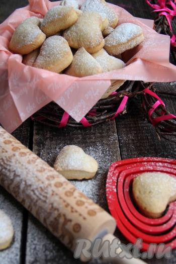 Готовое песочное печенье "Сердечки" переложить на тарелку, дать немного остыть, а затем присыпать сахарной пудрой и подать к столу.