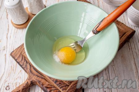 В миску вбейте куриное яйцо, добавьте соль. 