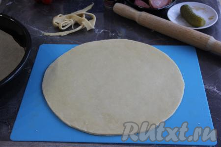 Раскатать тесто на присыпанной мукой поверхности скалкой в круг. Я раскатала в круг диаметром 30 см. Края обрезала для того, чтобы форма пиццы была более ровной.