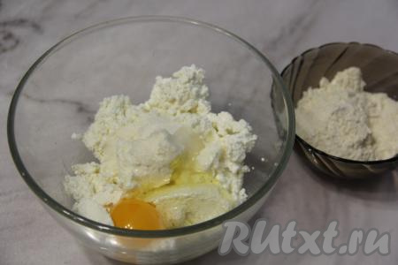 В творог добавить яйцо, соль и сахар, перемешать столовой ложкой (или вилкой) до получения однородной творожной массы.